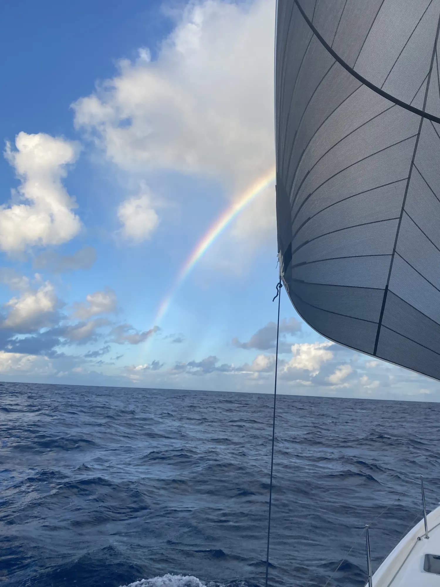 A rainbow over open water, sailing aboard Pascal